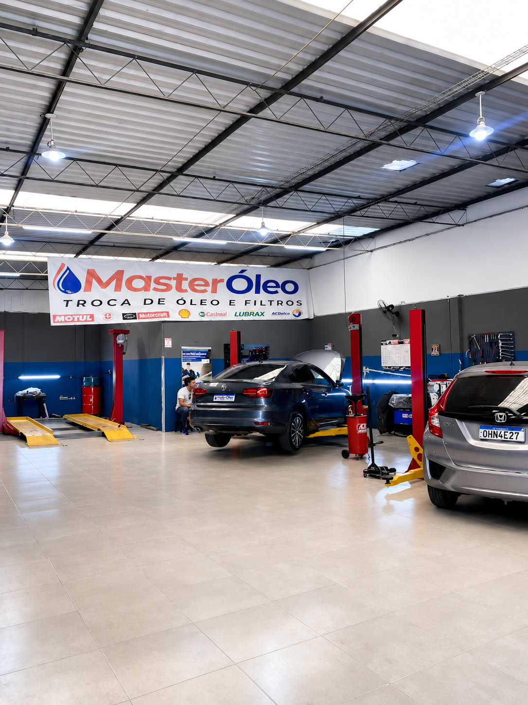 Interior da oficina Master Óleo com elevadores e veículos em atendimento